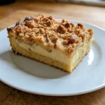 Nahaufnahme der knusprigen Zimtstreusel auf dem Apfelkuchen, frisch aus dem Ofen.